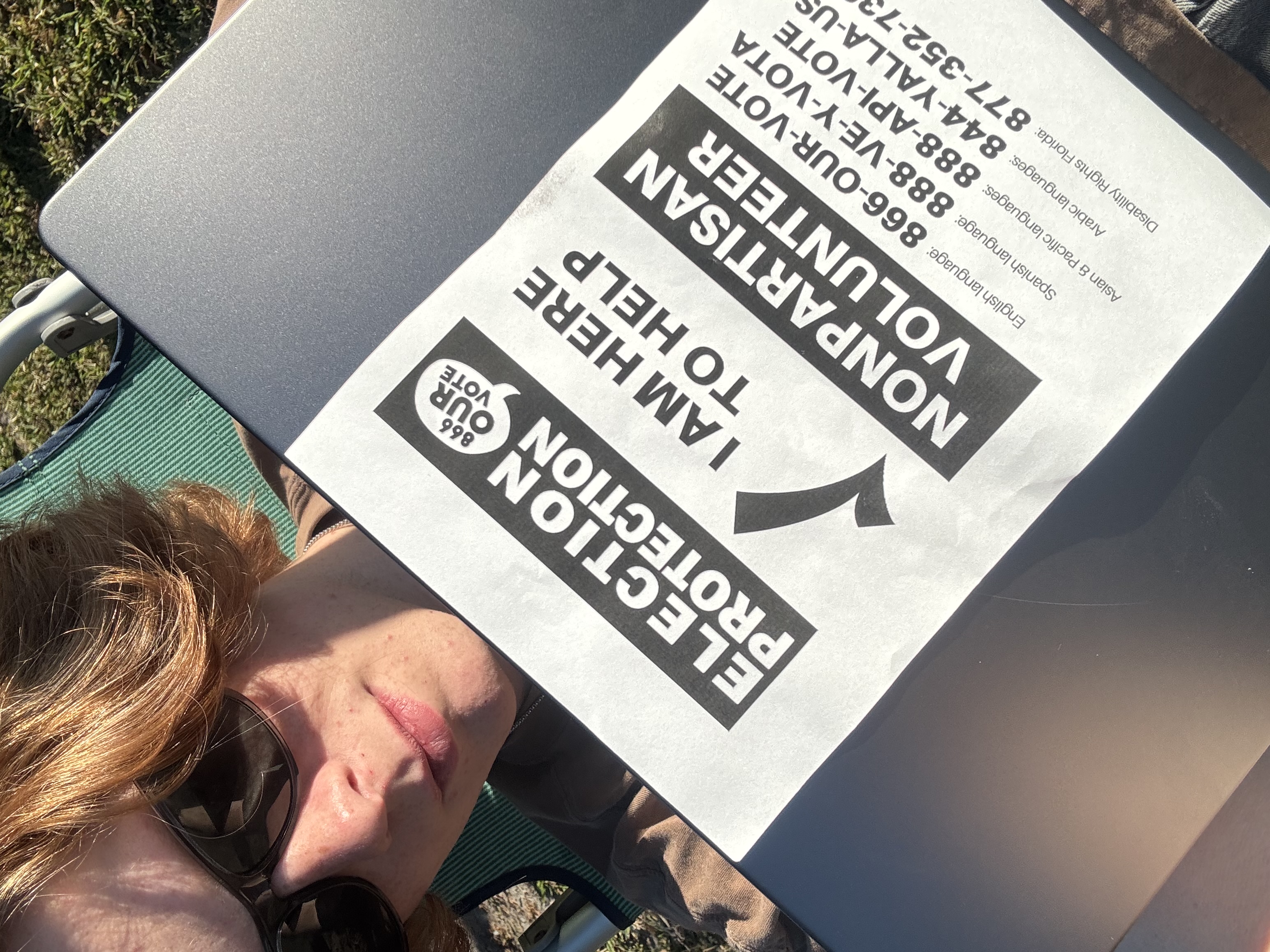 Volunteer holding multilingual election protection information